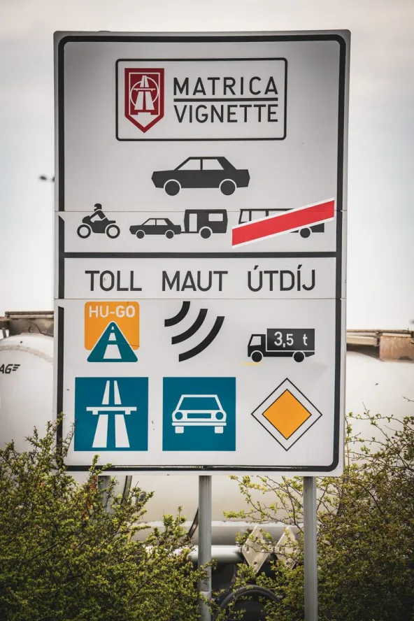 Hungarian motorway vignette sign at the Rajka border crossing showing Matrica Vignette requirements for cars, motorcycles and caravans, plus HU-GO toll system for vehicles over 3.5 tonnes, photographed by Noemi Karacsonyi.