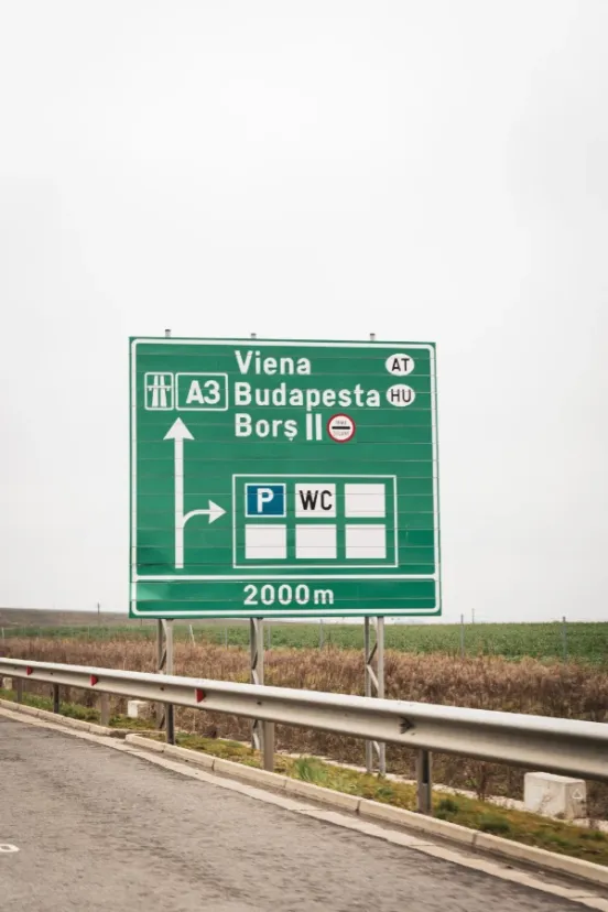 Green A3 motorway sign in Romania directing to Viena Austria, Budapesta Hungary and Borș II border crossing with parking and WC facilities at 2000m